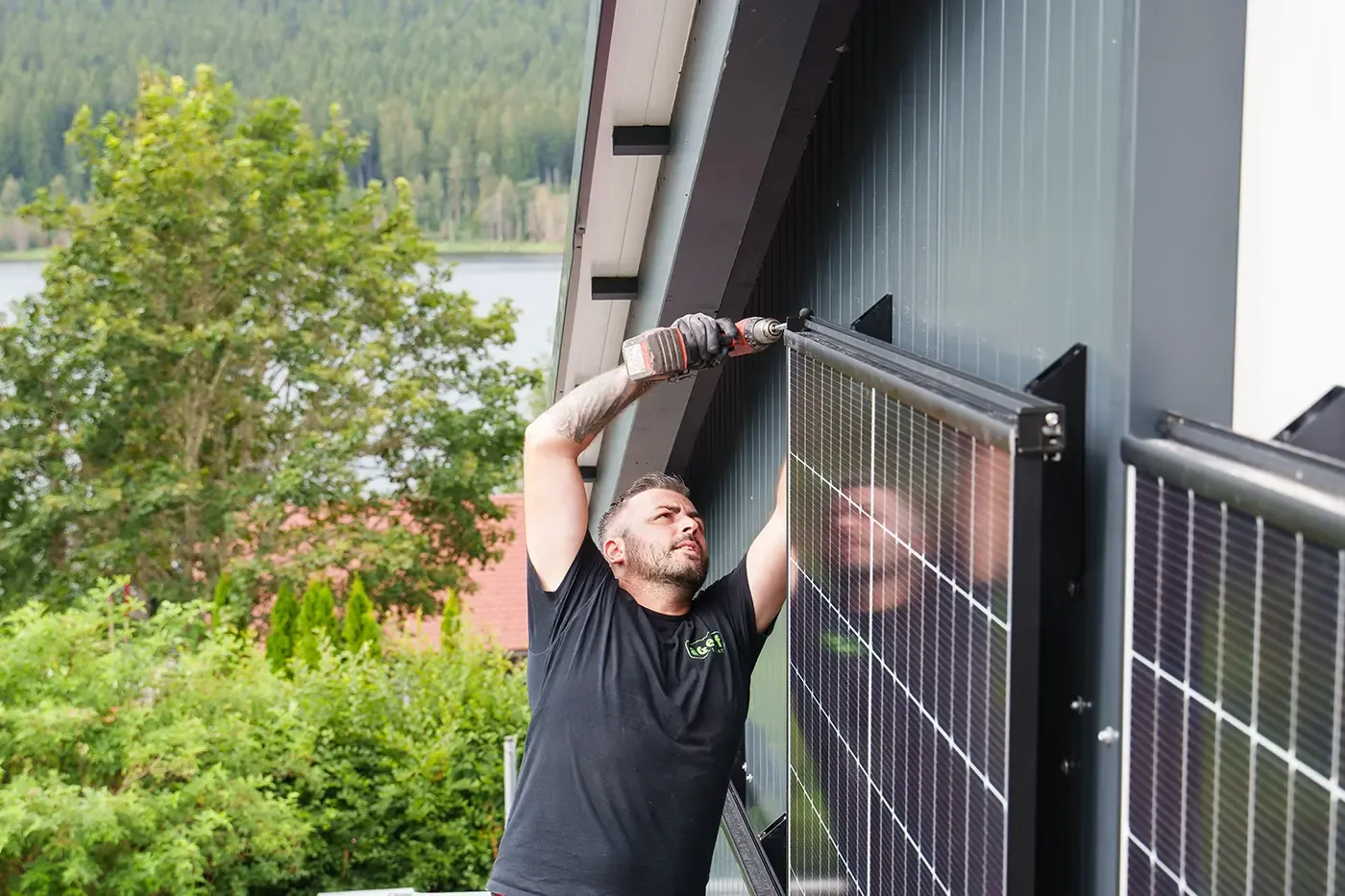 AGEFF Solar Mitarbeiter montiert ein Solarmodul an einer Fassade